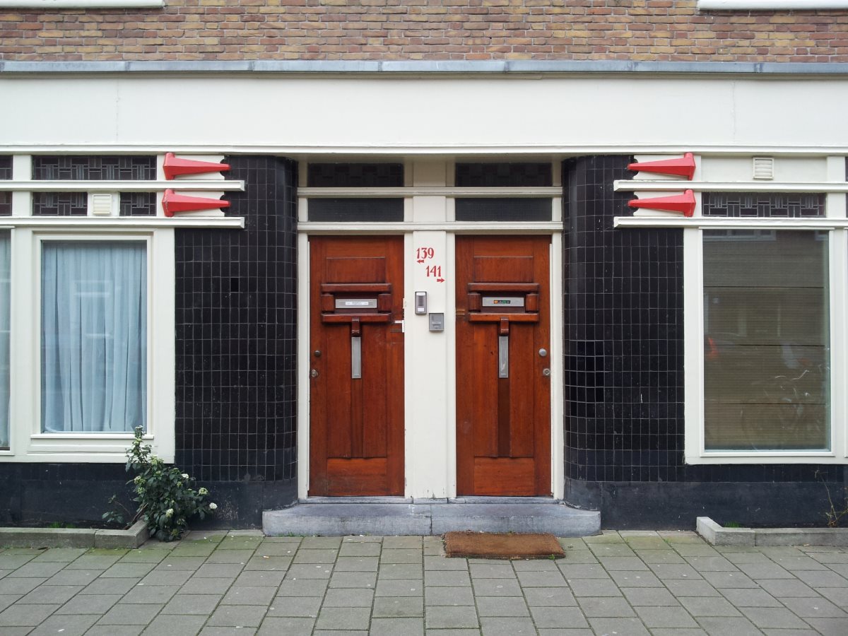Van Speijkstraat. J. Zietsma, 1924. Pijlvormige ornamenten helpen om in de lange gevelwand de portieken te markeren.